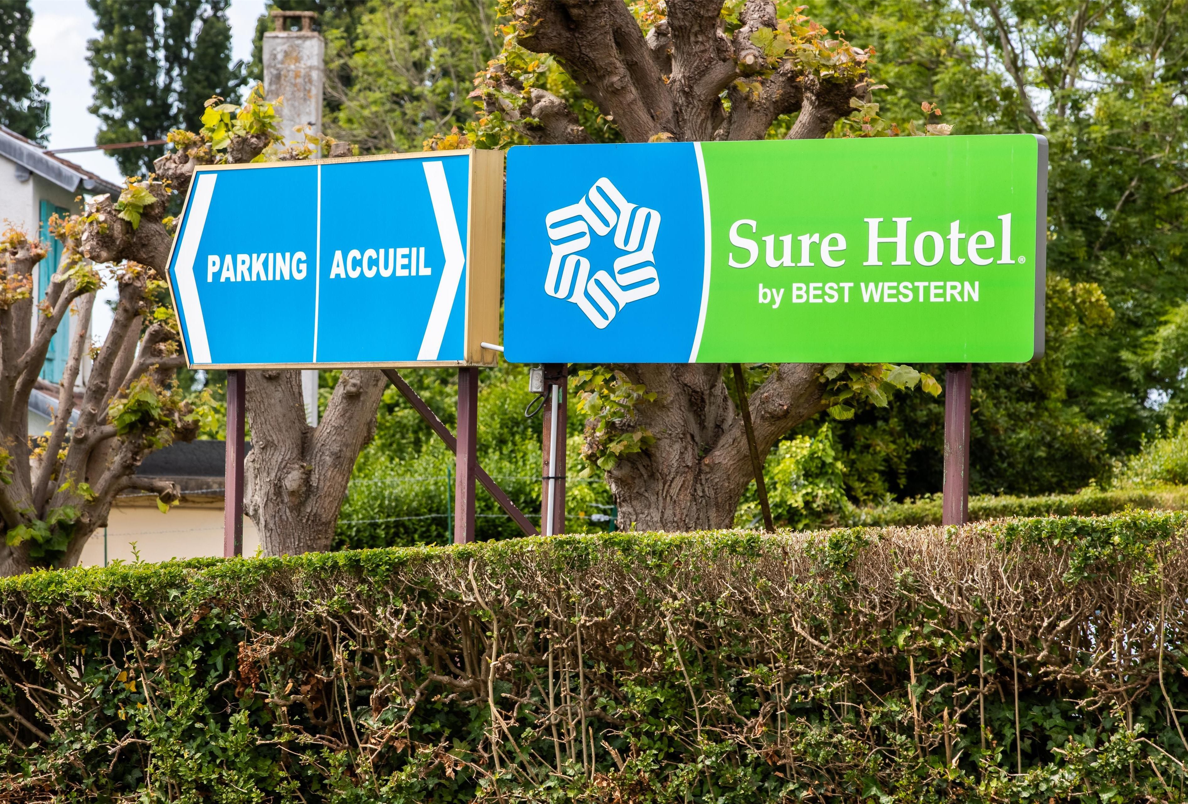 A hotel sign with directions to parking and the hotel entrance, and the name 'Sure Hotel by Best Western'.