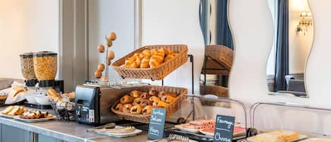 Una barra de buffet con diversas opciones de comida, como pan, jamón y queso.