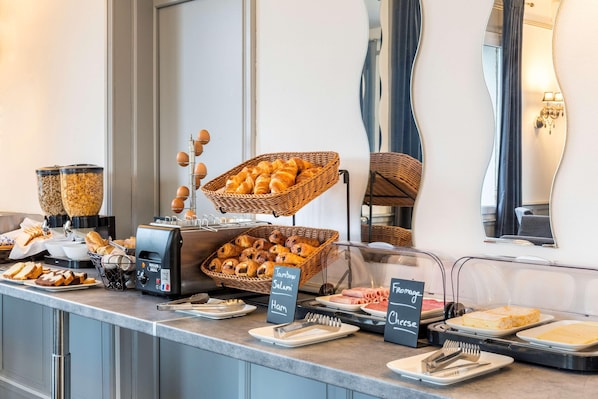 Un buffet proposant une variété d’aliments, notamment du pain, du jambon et du fromage.