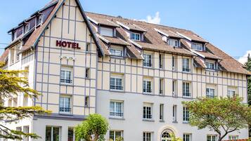 Ett hotell i traditionell europeisk arkitektonisk stil, med ett sadeltak och många fönster.