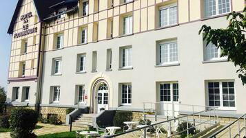 A hotel with a traditional facade, multiple windows, and a staircase leading to the entrance.