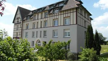 Ein großes, mehrstöckiges Gebäude mit einer symmetrischen Fassade, das helle und dunkelbraune Verkleidungen kombiniert.
