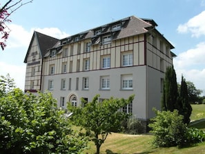 A large, multi-story building with a symmetrical facade, featuring a mix of white and dark brown paneling. - Sure Hotel by Best Western Port Jerome - Le Havre (Port-Jérôme-sur-Seine)
