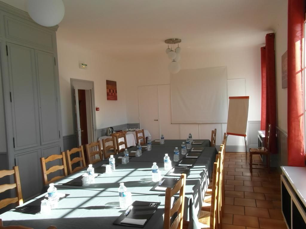 Ett konferensrum med ett långt bord, stolar och vattenflaskor.