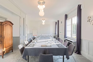 A conference room with a long table, chairs, water bottles, and a wooden cabinet. - Sure Hotel by Best Western Port Jerome - Le Havre (Port-Jérôme-sur-Seine)