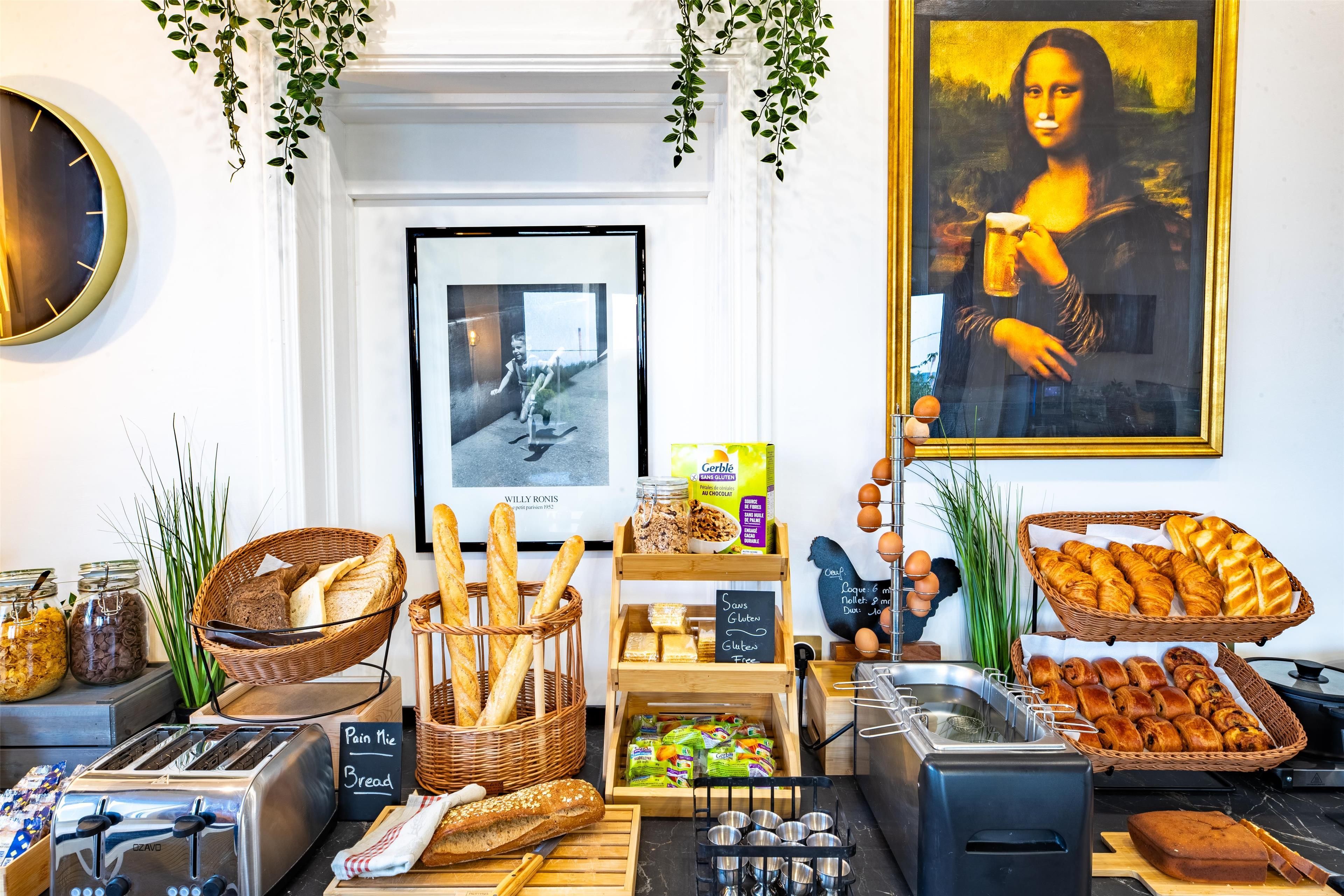 A breakfast buffet with various breads, pastries, and a painting of the Mona Lisa.