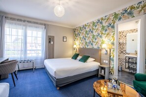 A hotel room with a bed, a desk, a chair, a small table with a tray, and a bathroom visible through an open door. - Sure Hotel by Best Western Port Jerome - Le Havre (Port-Jérôme-sur-Seine)