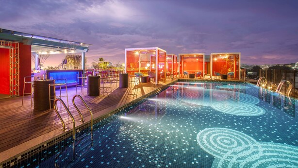 A rooftop pool area with a bar and seating area, surrounded by glass-enclosed spaces. - Hyatt Place Hyderabad Banjara Hills (Hyderabad)