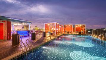 Una piscina al aire libre, sillones reclinables de piscina