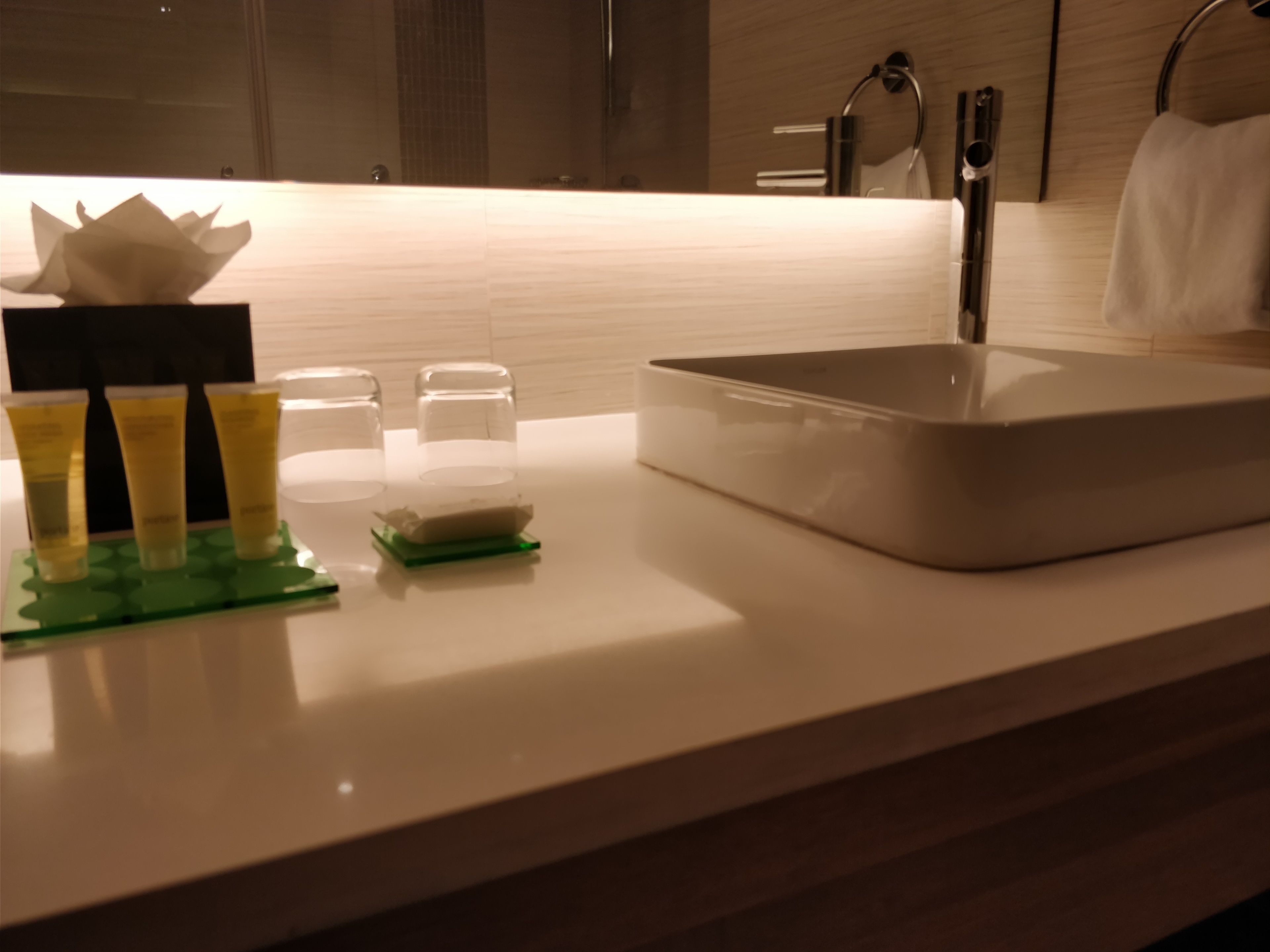 A bathroom with a white sink, a mirror, and a towel rack.