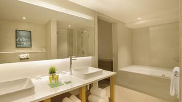 A modern bathroom with two sinks, a large mirror, a shower, and a bathtub.