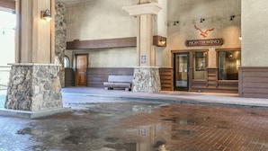 A reception area with a stone pillar, wooden bench, and a sign reading "NORTH WING". - Red Hawk Lodge 2275 (Keystone)