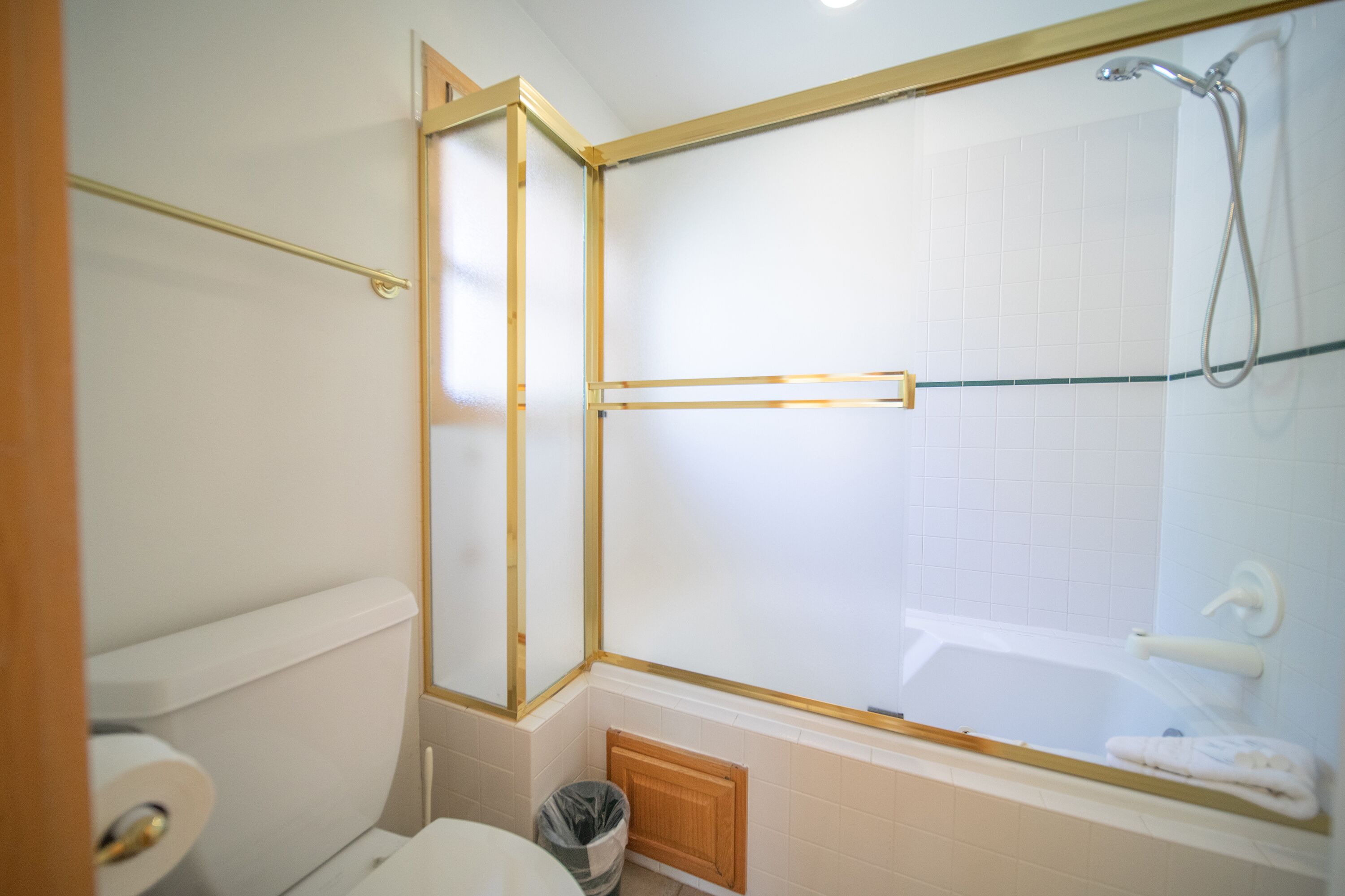 A bathroom with a toilet, a shower enclosure, and a towel rack.