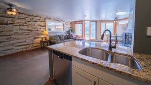 A kitchen with granite countertops, a dishwasher, and a double sink. - Lakeside 1481 by SummitCove Vacation Lodging (Keystone)