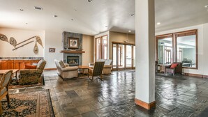 A spacious living area with a fireplace, comfortable seating, and a large window providing natural light. - Oro Grande 413 (Keystone)