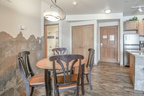 A kitchen with a dining table, chairs, wooden cabinets, and a refrigerator. - Black Bear 8052 by SummitCove Vacation Lodging (Keystone)