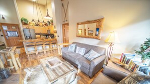 A cozy living room with a grey sofa, a wooden coffee table, and a rug.