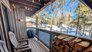 Eine Holzterrasse mit Stühlen und einem Holzstapel.