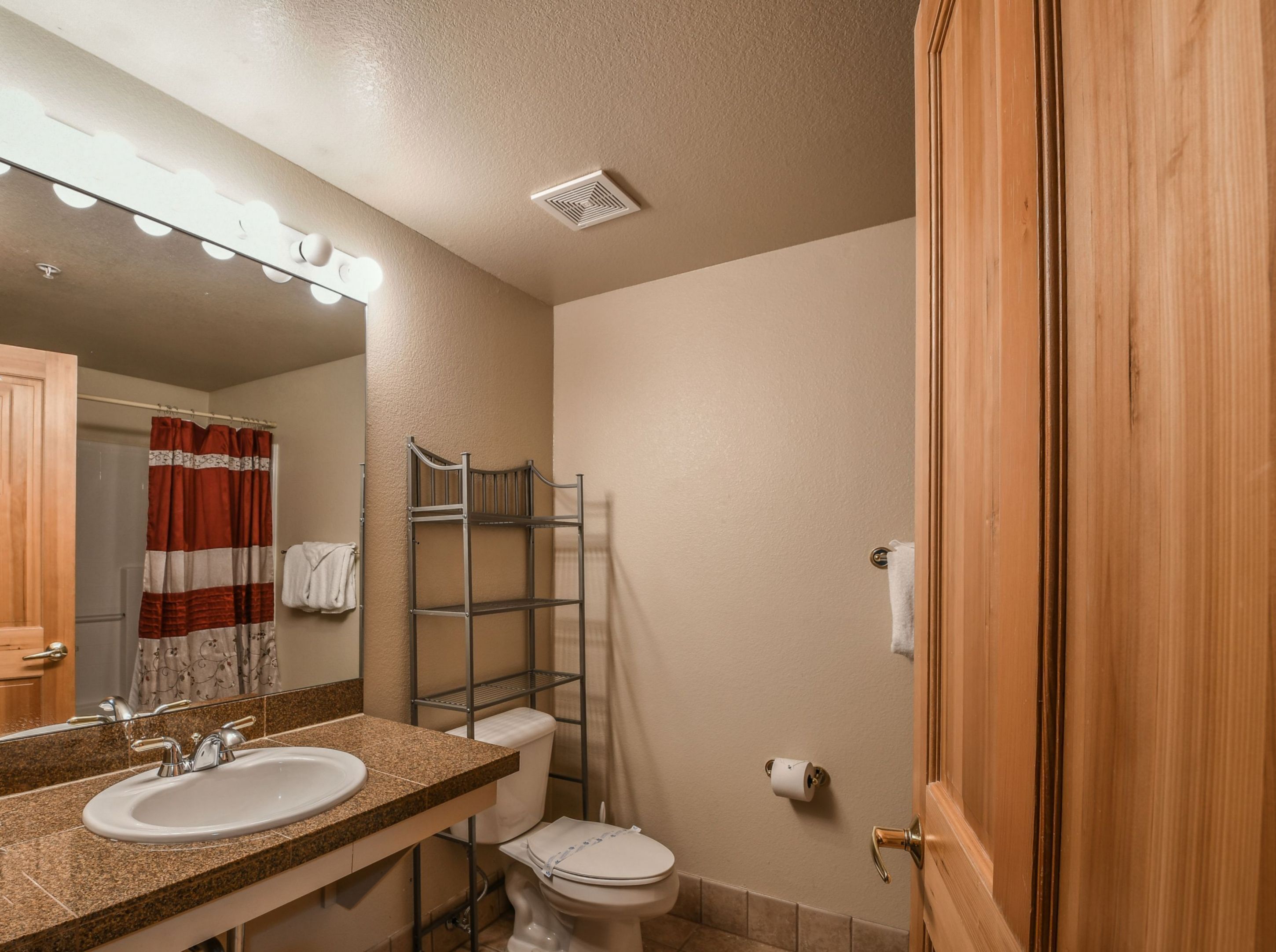 Un bagno con lavandino, specchio, doccia e WC.