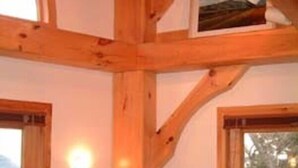 Ein Holzkamin mit hoher Decke, großen Fenstern und einer Wandleuchte.