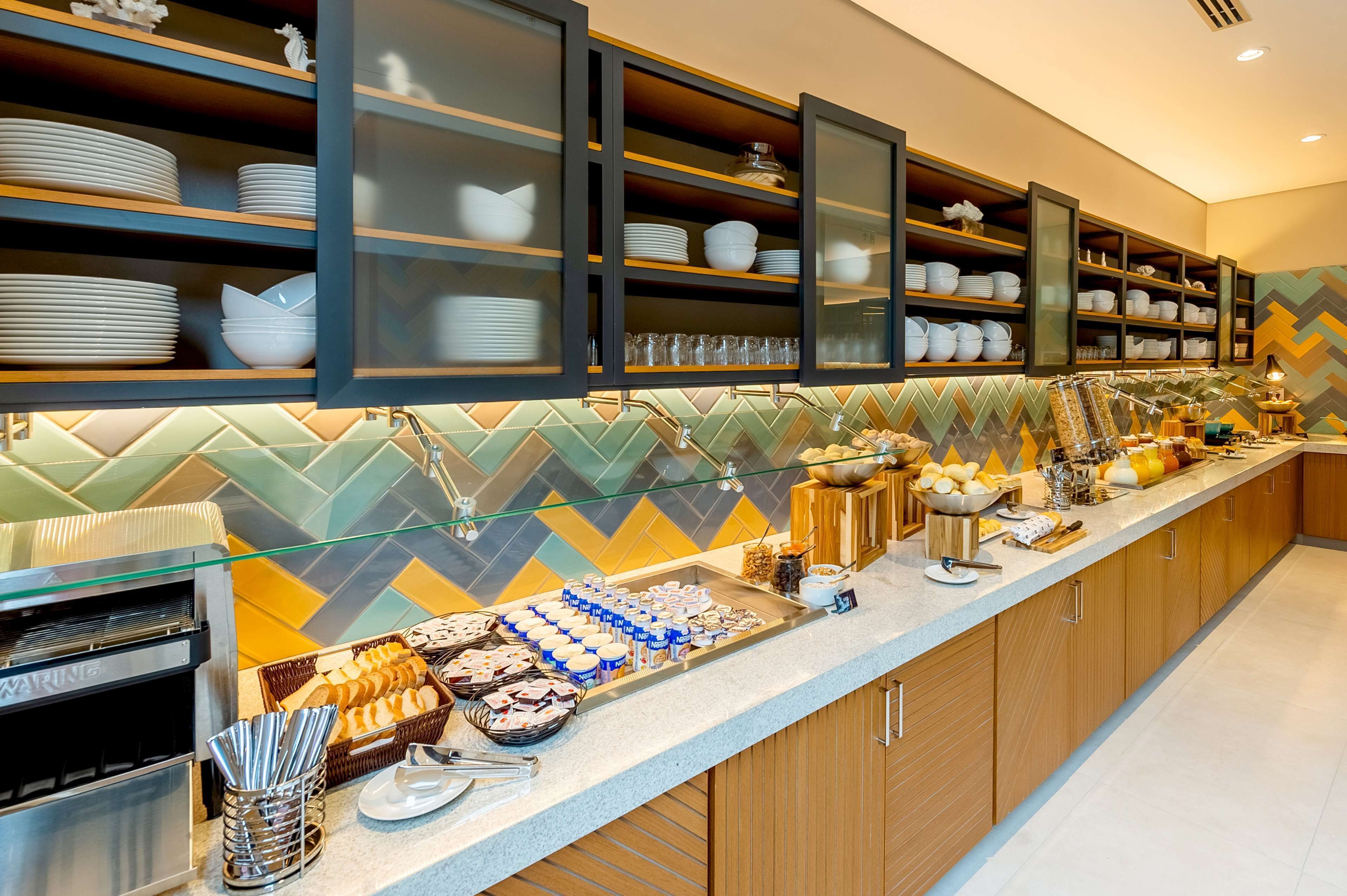 A buffet setup with various food items and glassware.