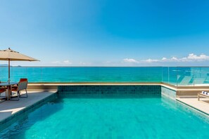 A clear blue sky, a swimming pool with a glass barrier, and a table with chairs. - Hyatt Place Macae (Macaé)