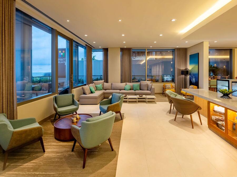 Una sala de estar moderna con un sofá grande, sillones, una mesa de centro y una zona de bar.