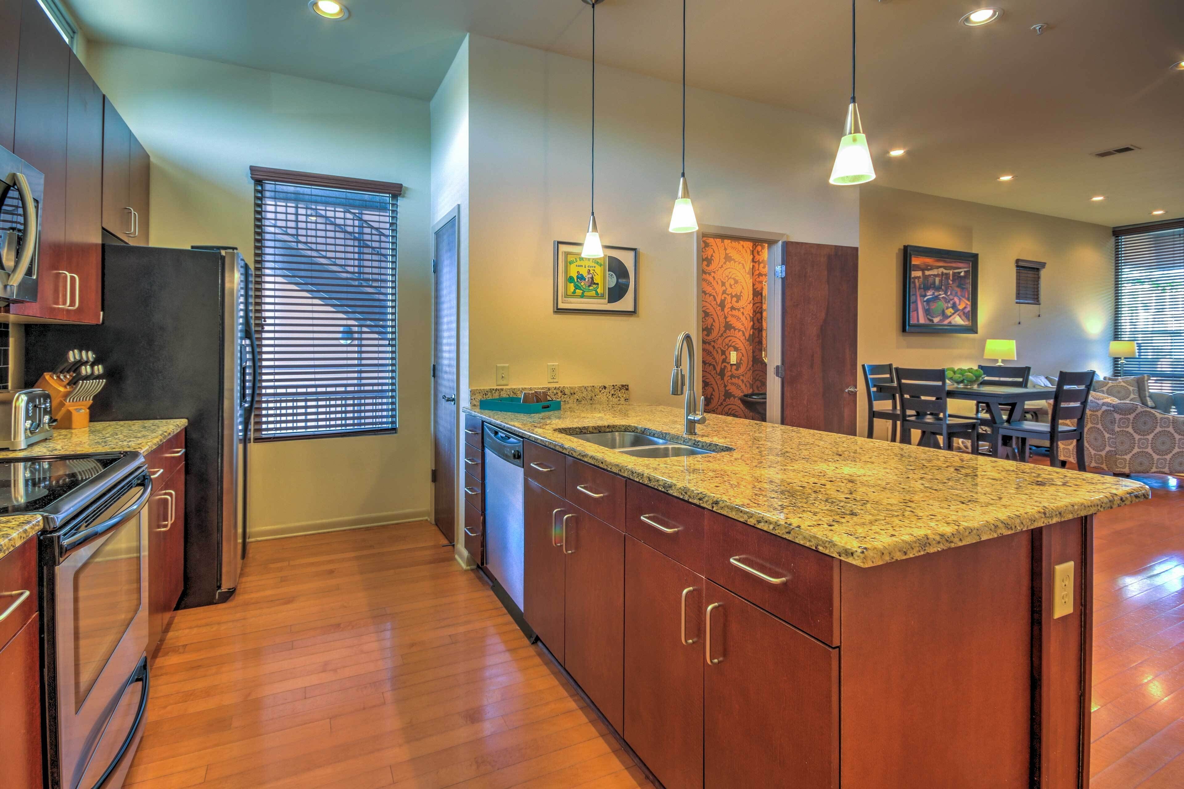 A modern kitchen with granite countertops, stainless steel appliances, and wooden cabinets.