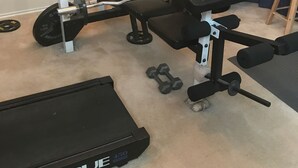 A home gym with a bench press, dumbbells, a barbell, and a treadmill. - Wonderful home (4 bdr, 3 bth) cozy! (Cibolo)