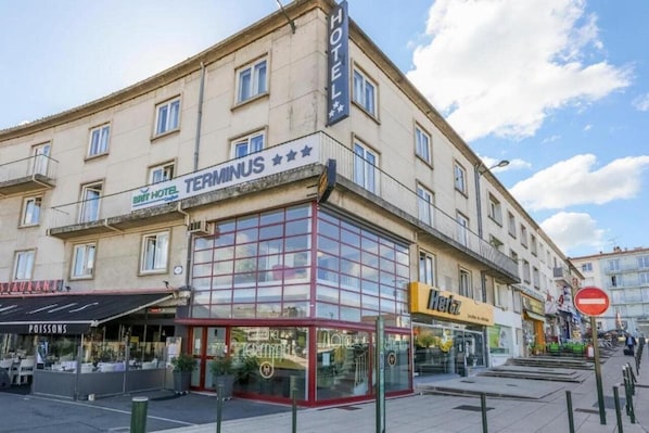 A hotel named TERMINUS with a glass storefront and a visible restaurant named POISSONS.