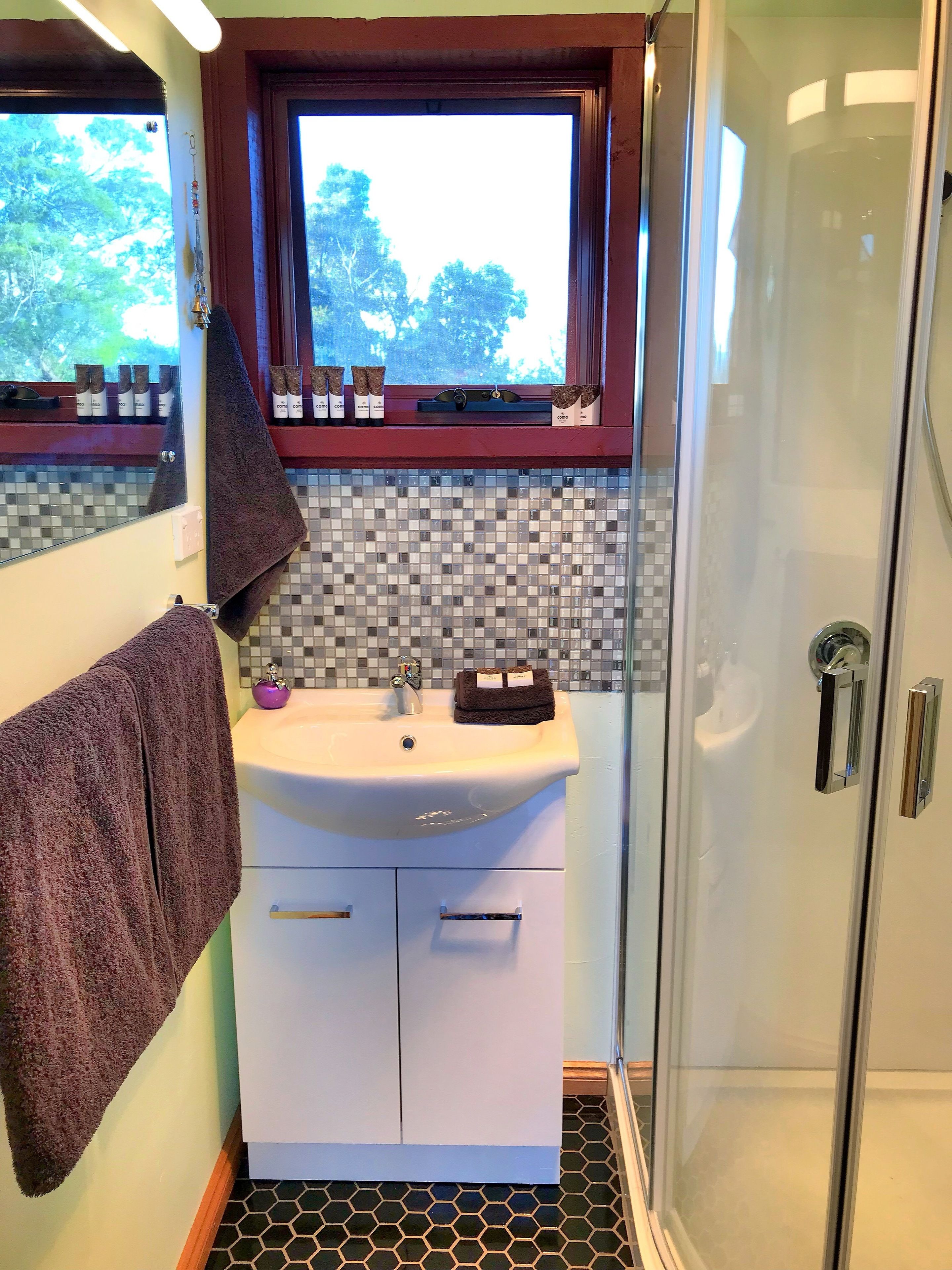 Un bagno con lavandino, specchio e finestra.