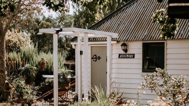 A rustic building with a corrugated metal roof and a white exterior. A sign reading "BENTMORE" is visible on the side. - Belmont Homestead (Swansea)