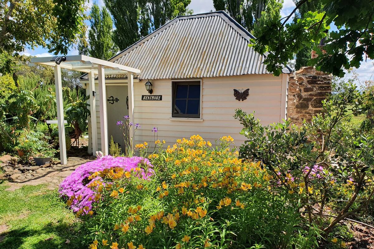 A small, single-story building with a corrugated metal roof, a sign reading "BENTMORE," and a butterfly decoration above the door.