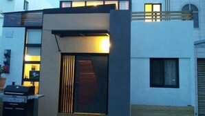 A modern two-story building with a flat roof, large windows, and a well-lit entrance.