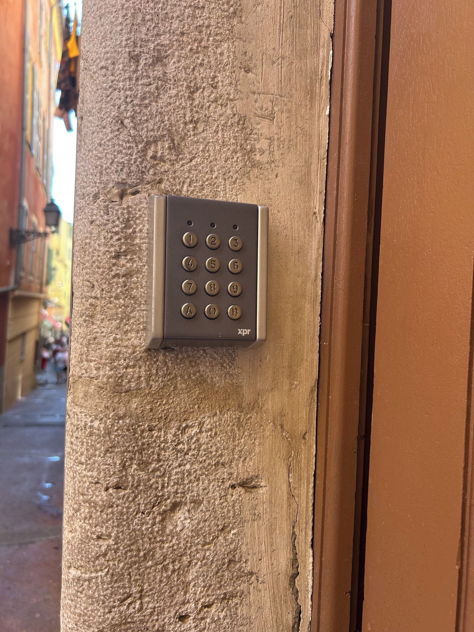 A keypad lock on a textured wall, likely for a hotel or apartment door.