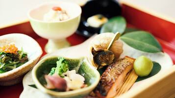 A traditional Japanese meal with various dishes including fish, vegetables, and a small bowl of soup.