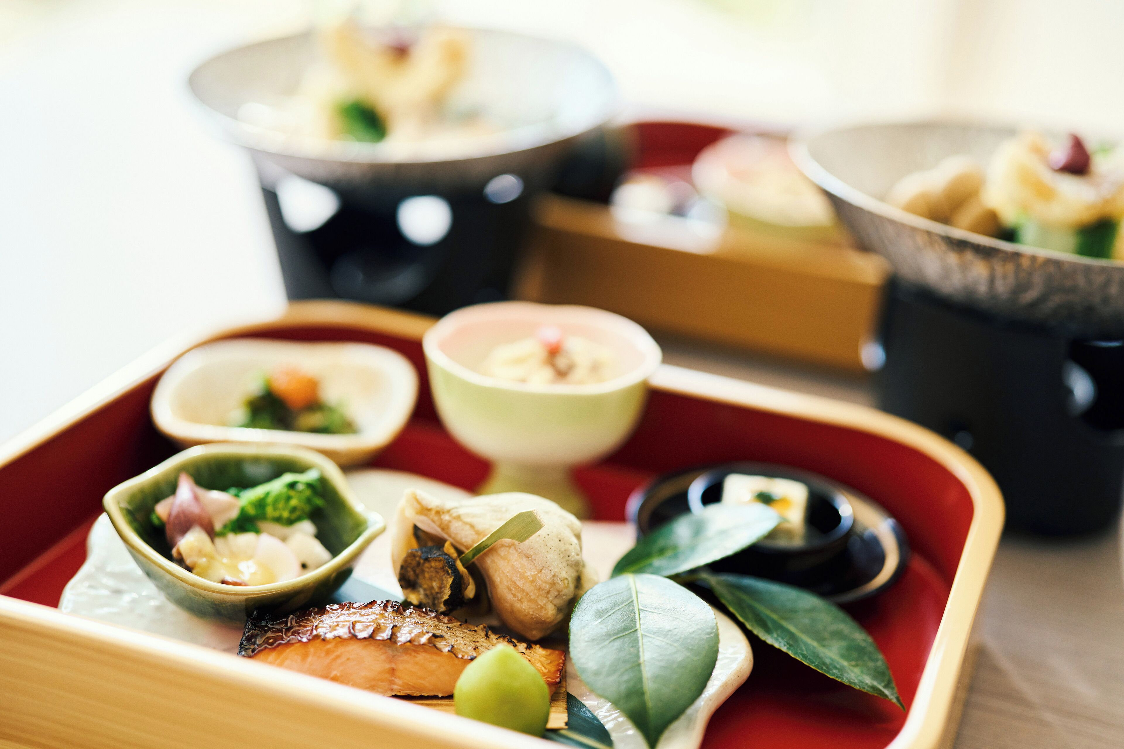 A traditional Japanese meal with various dishes and a tea set.