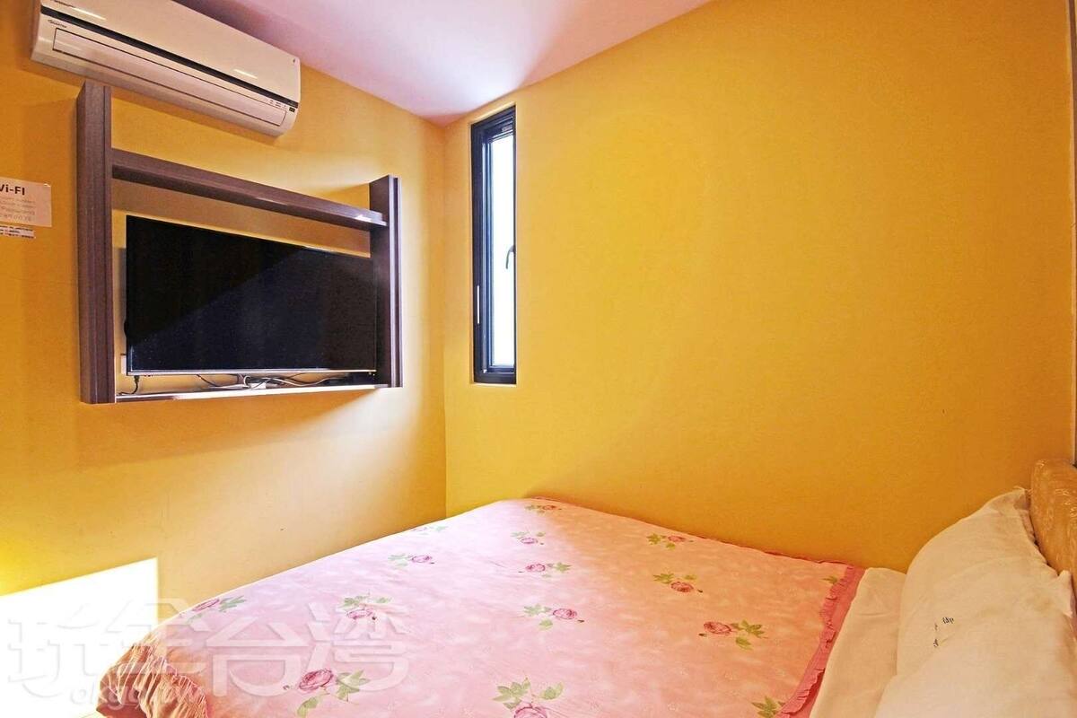 A room with a bed, a window, and an air conditioning unit.