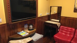 A compact living space with a television, a small refrigerator, a coffee maker, and a red sofa. - Tan Hsiang Yu B&B (Yuchi)