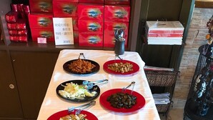 A buffet table with various dishes and a sign in the background. - Tan Hsiang Yu B&B (Yuchi)