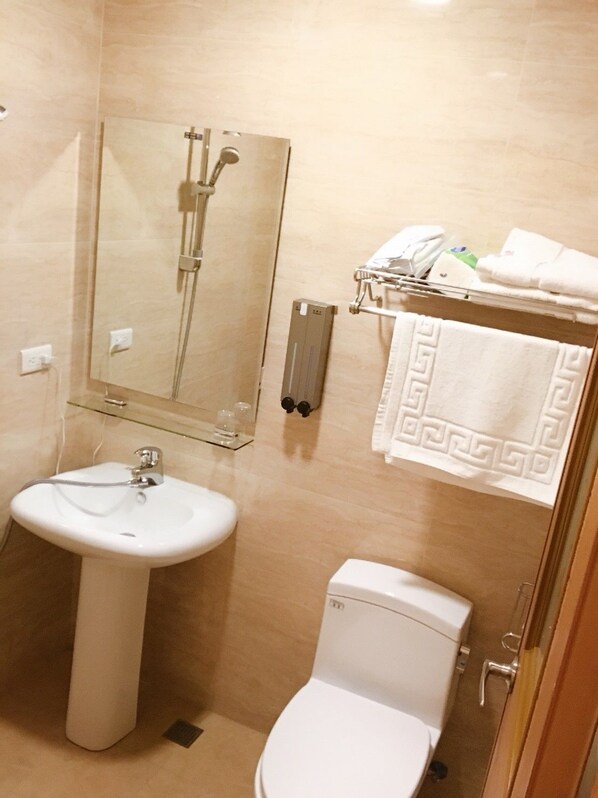 A bathroom with a sink, toilet, and a shower with a glass enclosure.