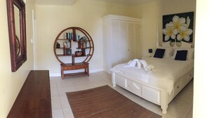 A bedroom with a bed, a wooden bookcase, a wardrobe, and a painting. - South Sea House Luxurious Apt No 1 (Cap Estate)