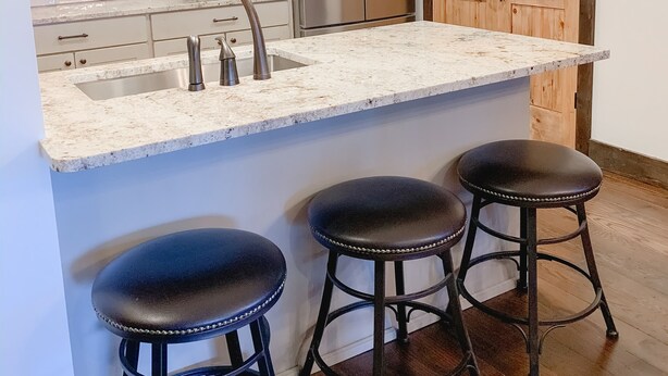 A kitchen with white cabinets, a stainless steel refrigerator, a sink, and two hanging pendant lights. - Whistlepunk #4 - Complete Renovation, Truly Slopeside, Near 2 Lifts & Village (Snowshoe)