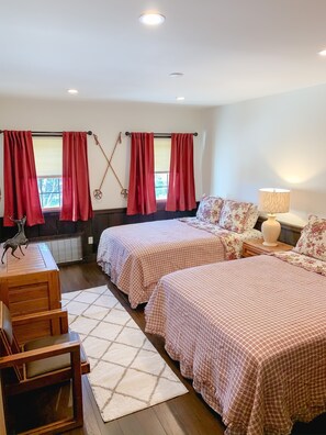 A bedroom with two beds, a wooden desk, a lamp, and a window with red curtains. - Whistlepunk #4 - Complete Renovation, Truly Slopeside, Near 2 Lifts & Village (Snowshoe)