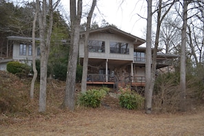 A two-story house with a large porch and a staircase leading to the upper level.