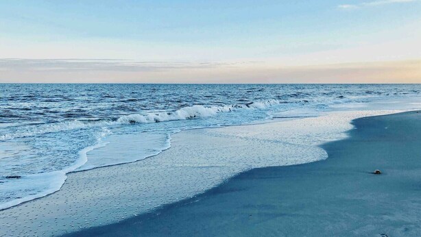 A beach with waves gently lapping onto the shore. - Coastal King Couples Retreat Oceanfront Beach Property Convenient to Everything! (Hilton Head Island)