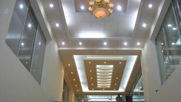 A modern interior with a central staircase, recessed lighting, and a decorative chandelier. - Nirvana Inn (Sylhet)