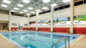 An indoor swimming pool with multiple lanes, surrounded by a tiled floor and a red wall. - Nirvana Inn (Sylhet)