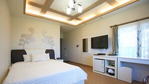 Une chambre d’hôtel avec un grand lit, un bureau avec un ordinateur, une télévision et une fenêtre avec des rideaux.