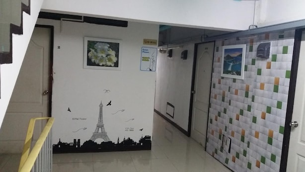 A hallway with a mural of the Eiffel Tower, a 'No Smoking' sign, and a door with a patterned tile design. - Natcha Place Rangsit Donmuang (Lam Luk Ka)